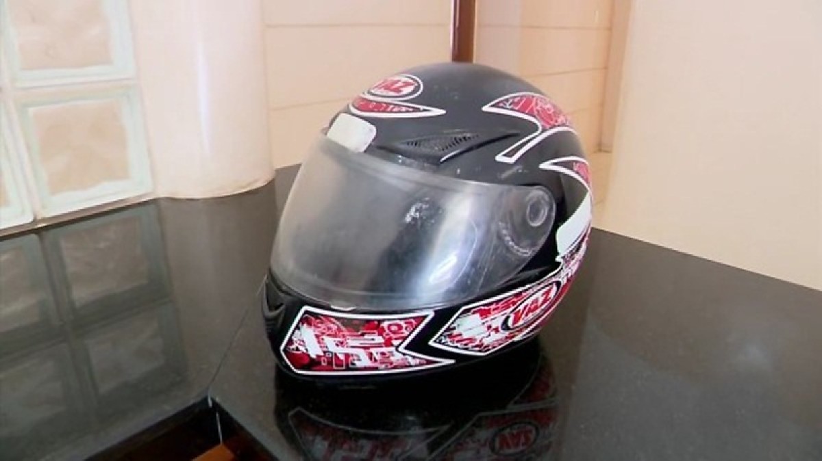 homem usa capacete para bater na mulher