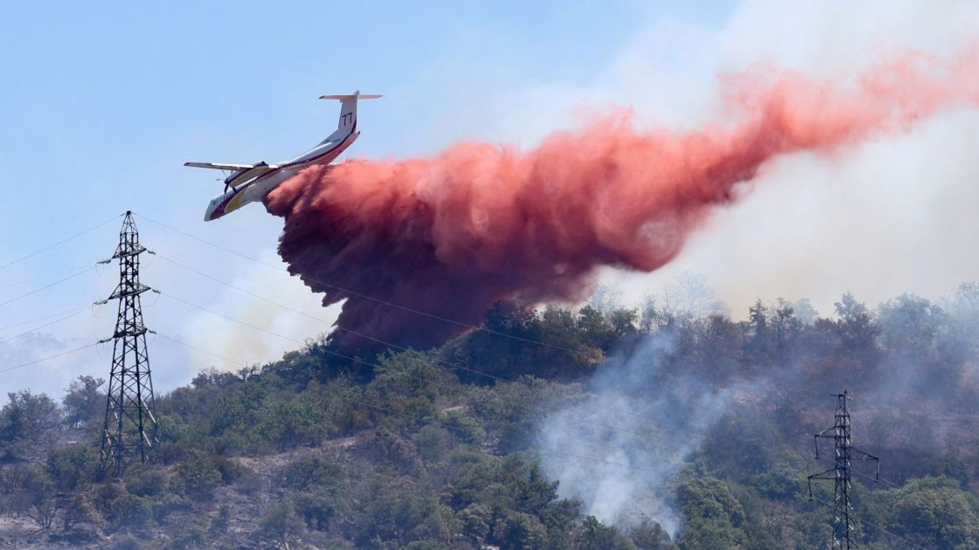 Avião de combate a incêndios lança retardante de fogo enquanto sobrevoa um incêndio florestal em Ille-sur-Têt, perto de Perpignan, na França6 de julho de 2026. REUTERS/Alexandre Dimou  • REUTERS