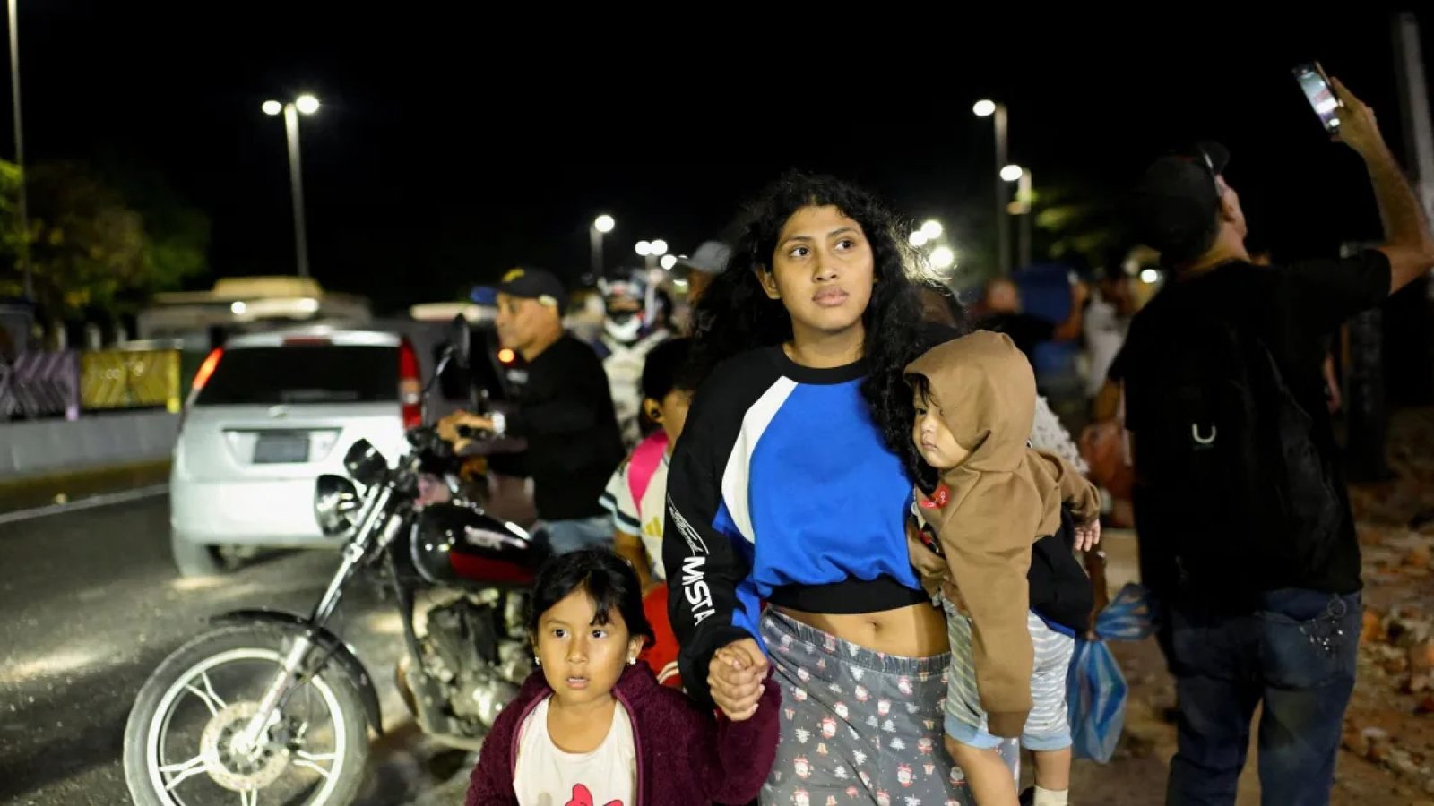 Mulher caminha com crianças após um terremoto, em Caracas, Venezuela, em 24 de junho de 2026REUTERS/Maxwell Briceno  • REUTERS
