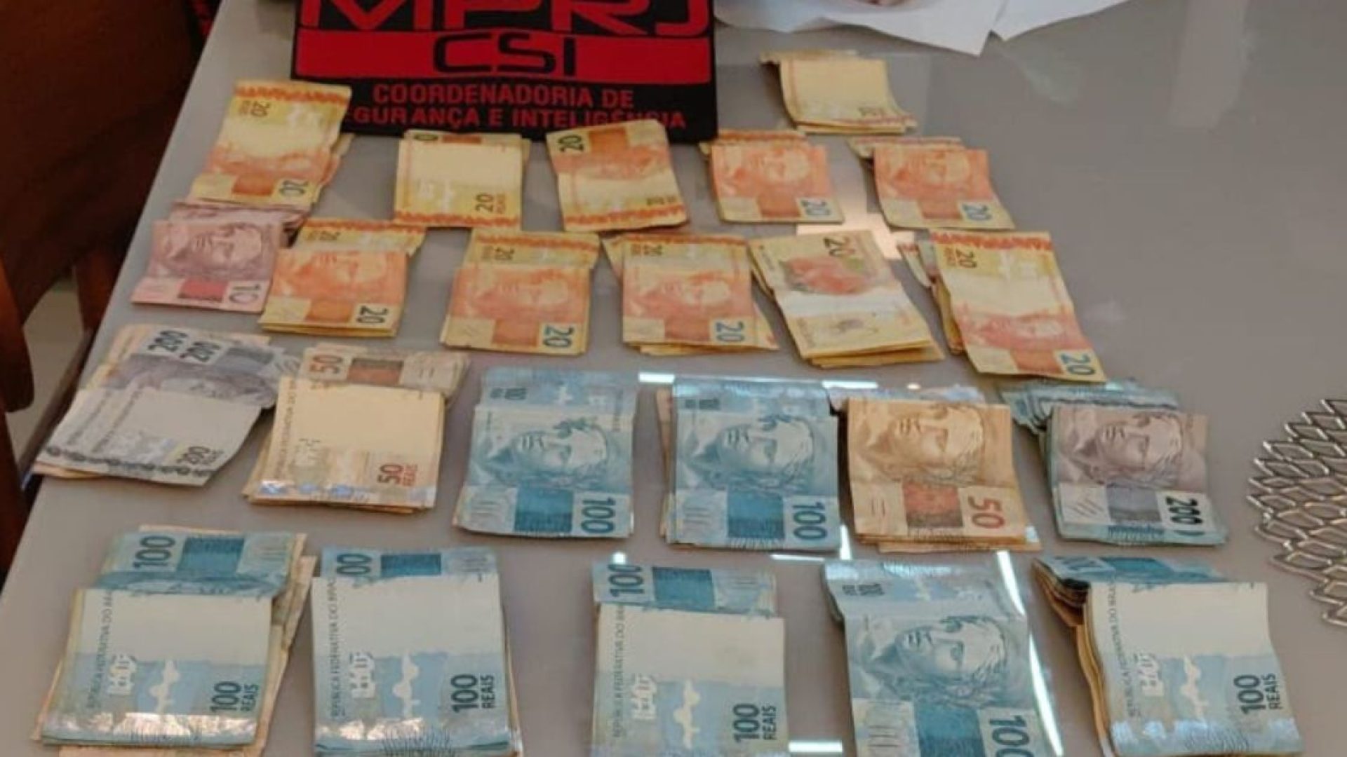 Celulares e quantia em dinheiro apreendidos durante a operação do GAECO/MPRJ que investiga policiais militares suspeitos de receber propina de traficantes na Baixada Fluminense.  • Reprodução - MPRJ
