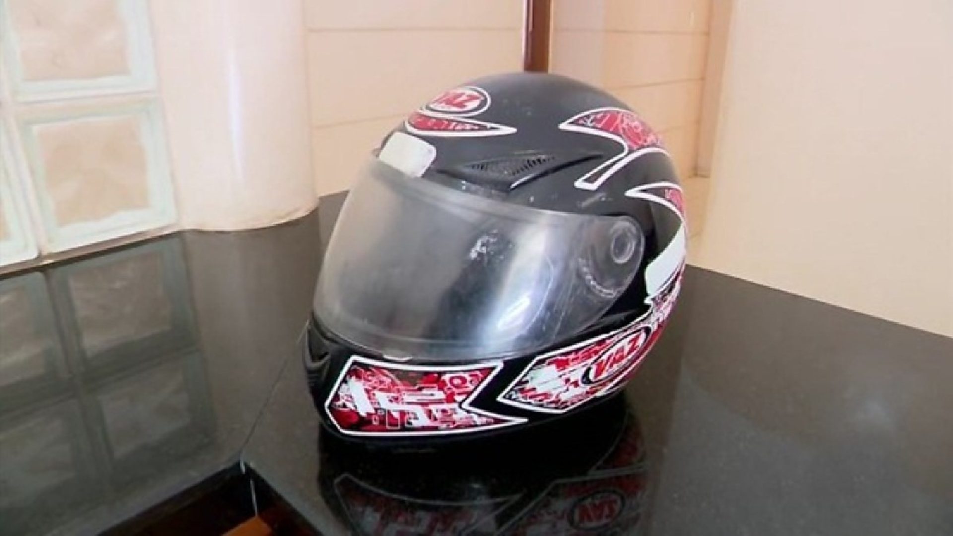 homem usa capacete para bater na mulher